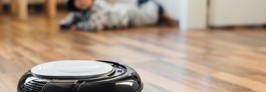 robotic-vacuum-cleaner-on-laminate-floor-with-baby-boy-on-background_t20_9kbyjy